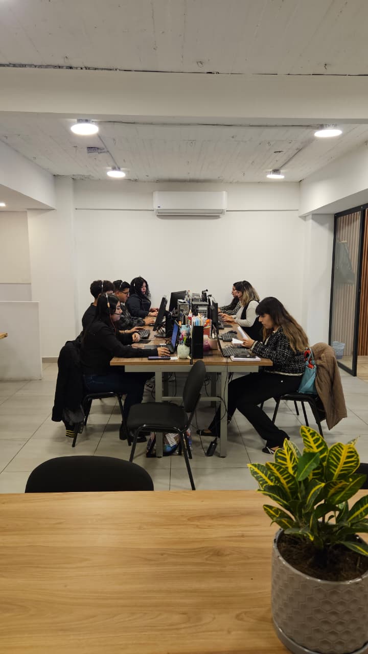 Área de trabajo compartida con escritorios y sillas ergonómicas